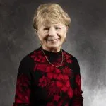 Smiling, older, female patient wearing a black & red floral shirt