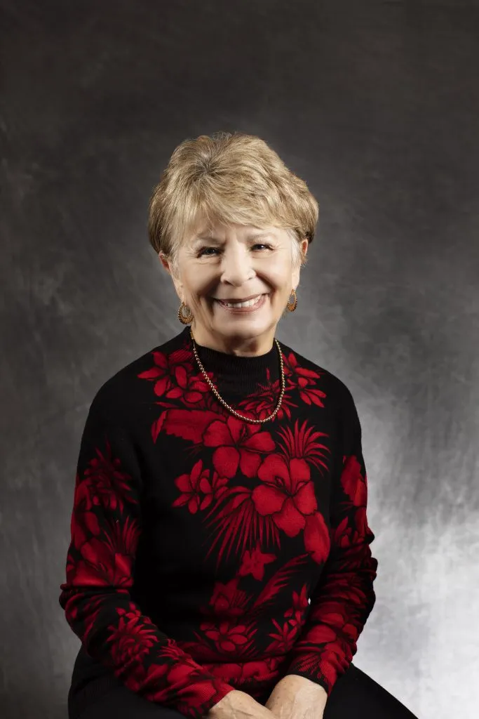 Smiling, older, female patient wearing a black & red floral shirt