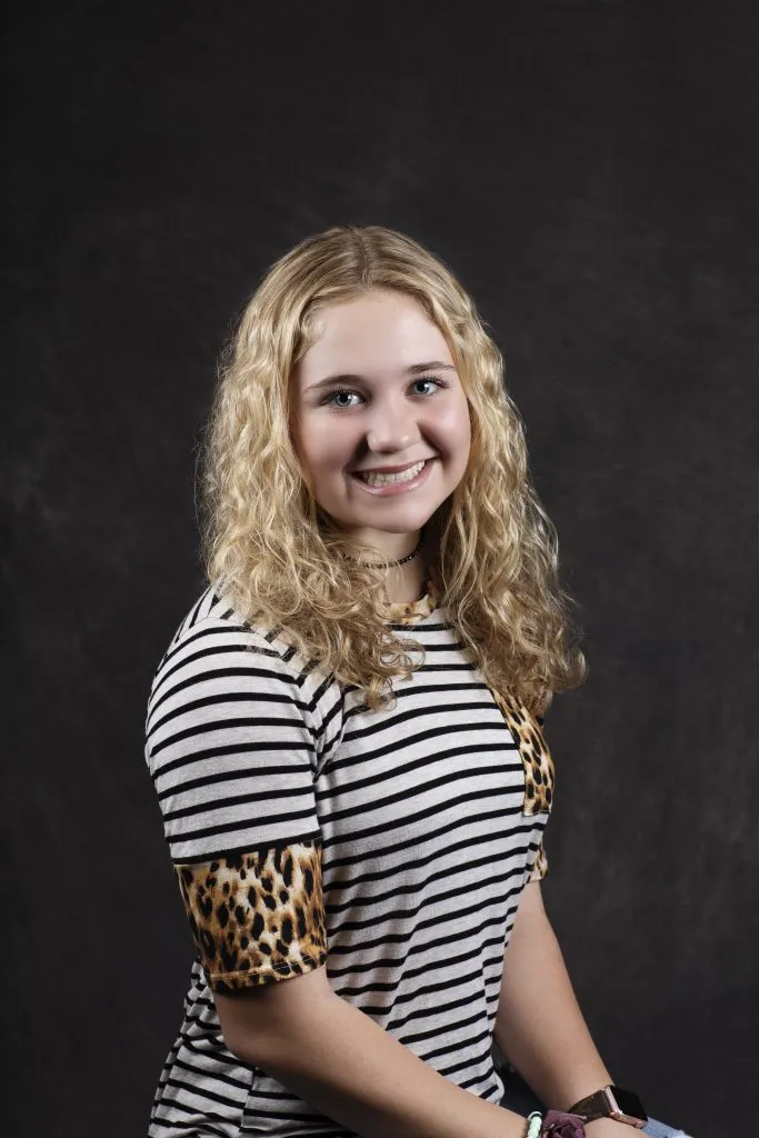 Smiling, young, female patient wearing black & white stripes