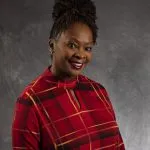 Smiling, female patient wearing red plaid shirt