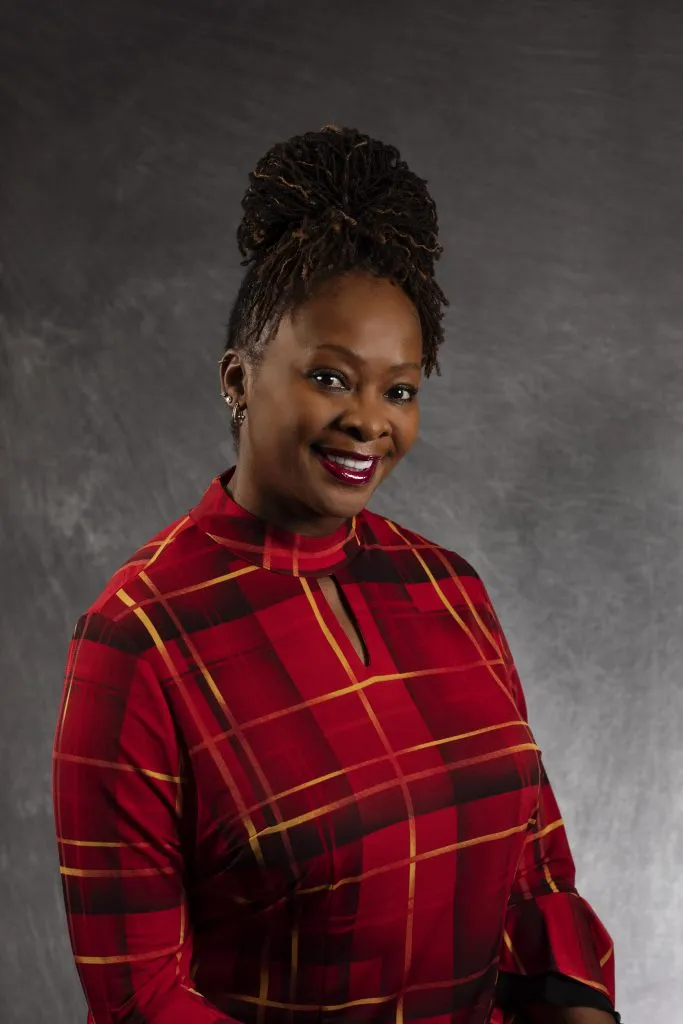 Smiling, female patient wearing red plaid shirt