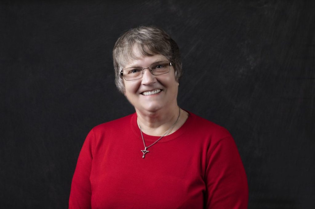 Smiling, older, female patient wearing a red shirt