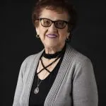 Smiling, older, female patient wearing black & grey