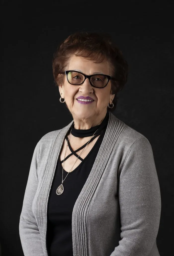 Smiling, older, female patient wearing black & grey