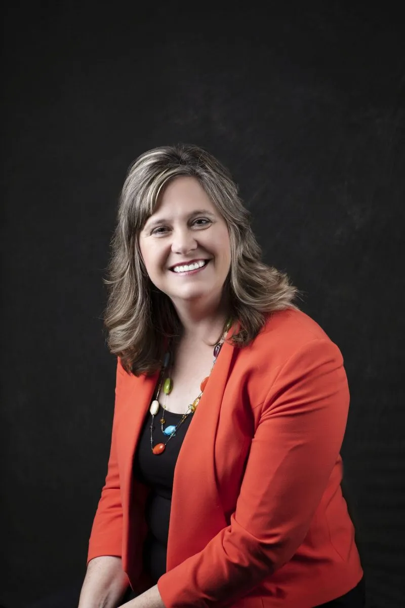 Smiling, female patient wearing an orange blazer