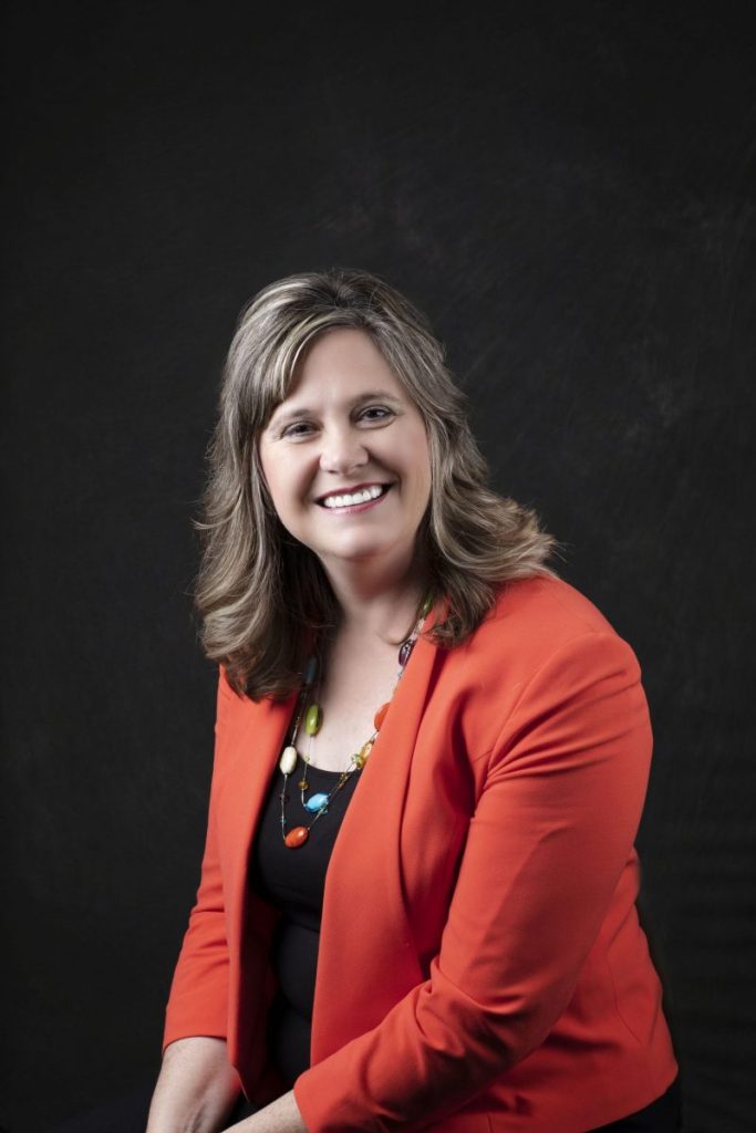 Smiling, female patient wearing an orange blazer