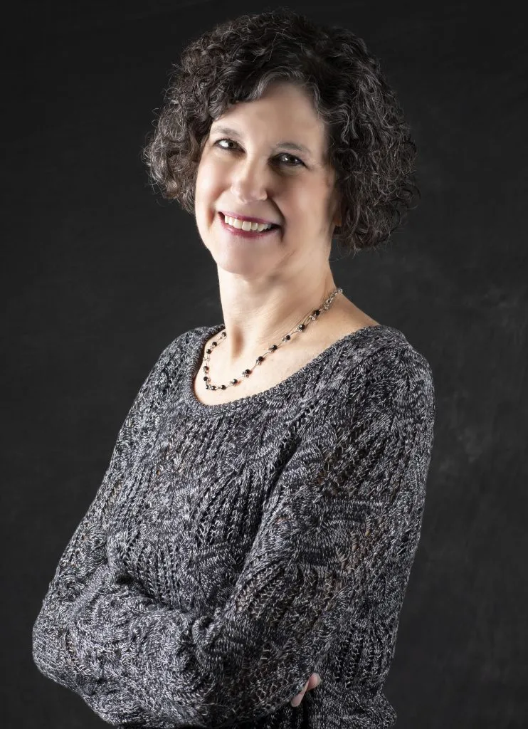 Smiling, older, female patient wearing grey