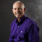 Smiling, older, male patient wearing a navy blue button up